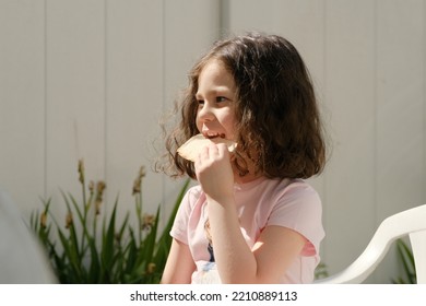 Cute Girl Eating Pita In The Backyard