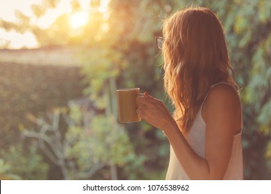 Cute girl enjoying morning coffee on the porch. - Powered by Shutterstock