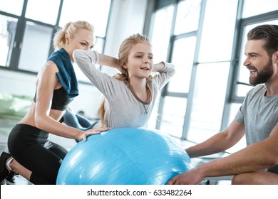 Cute Girl Exercising On Swiss Ball With Parents