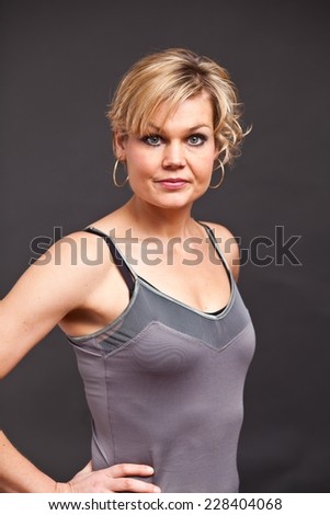 Similar – Close up front upper body portrait of one young athletic woman in sportswear in gym over dark background, looking at camera