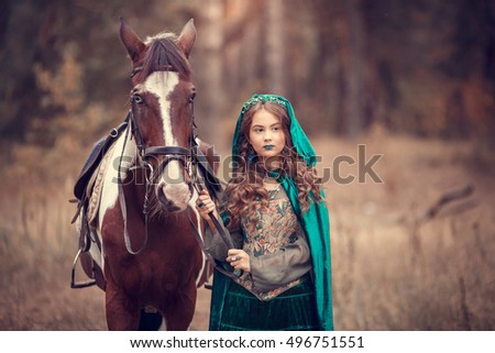 Cute girl in the green hooded cloak with a horse. Effect of toning.