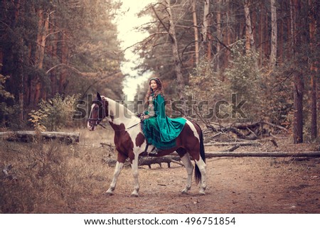 Cute girl in the green hooded cloak riding a horse. Effect of toning.