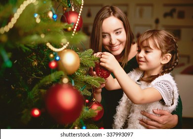 Cute Girl And Her Mother Decorating Firtree On Christmas Eve