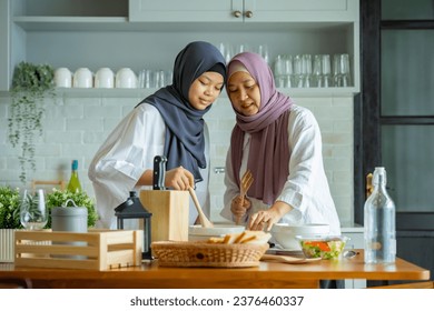 Cute Girl And Her Muslim Mom In Hijab Preparing Pastry For Cookies In Kitchen, Baking Together At Home. Islamic Lady With Daughter Enjoying Doing Homemade Pastry - Powered by Shutterstock