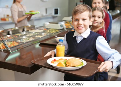 Cute Girl Holding Tray With Delicious Food In School Cafeteria