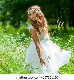 Cute Girl Holding White Dress In Green Field.