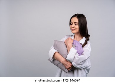 Cute Girl In Home Clothes And Hugging My Pillow Smiling, Dark Hair In A Braid, The Concept Of Comfort And Home.