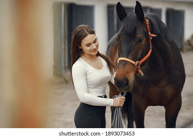 Cute girl with a horse. Lady in a white t-shirt. Woman in a summer ranch. - Powered by Shutterstock