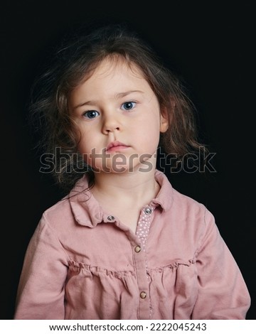 cute girl making expressive faces in the studio against a black background