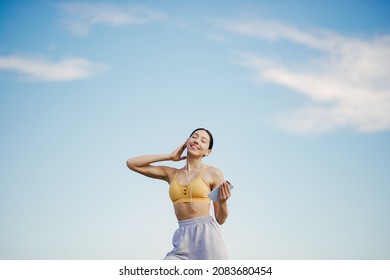 Cute girl with phone training on a sky backgroung