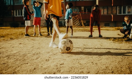 Cute Girl Playing Keepie Uppies with a Soccer Ball Together with Multiethnic Kids in the Neighborhood. Happy Boys and Girls Juggling the Ball in the Air. Concept of Sports, Childhood, Friendship. - Powered by Shutterstock