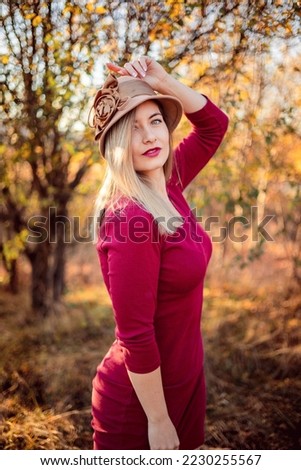 Similar – Blonde woman with hat taking a walk in the forest at sunset with the sun in the background.