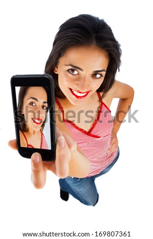 Cute girl with red lipstick taking selportrait with phone - isolated on white.