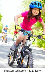 A cute girl riding her bicycle with competitors far behind