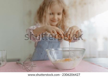 cute girl selective focus, preparing food, broke a fresh egg into a transparent bowl.
