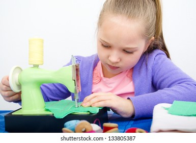 Cute Girl Sewing On A Sewing Machine At Home