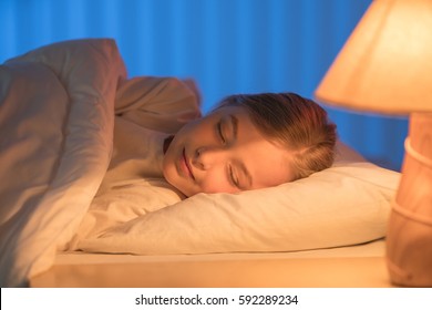 The Cute Girl Sleeping On The Bed. Evening Night Time