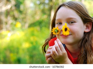 Cute Girl Smelling Fresh Picked Daisies Outside