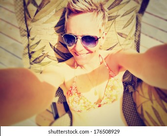 a cute girl smiling at the camera on a bright sunny day done with a retro vintage instagram filter - Powered by Shutterstock