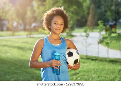 Cute girl with soccer ball and bottle of water standing on the street - Powered by Shutterstock