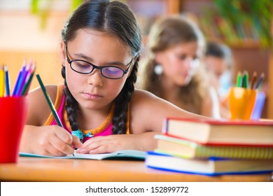 Cute girl studying in classroom at school