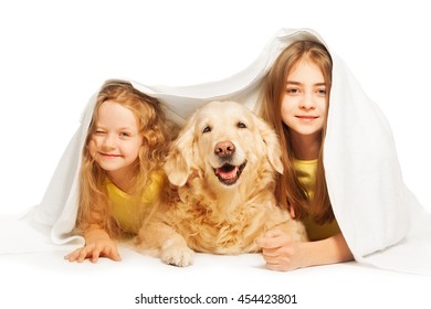 Cute girls hiding under the white blanket with dog - Powered by Shutterstock