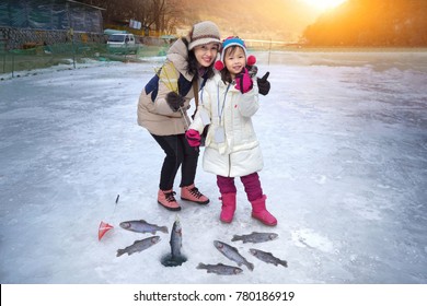 Cute Girls Are Sitting On The Floor Of Ice Fishing.Ice Fishing Tournament. Ice Fishing Travel At The North Pole. Ice Fishing Tour At Antarctica.