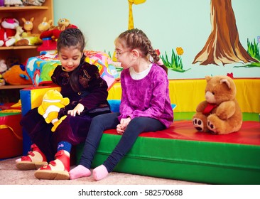 cute girls talking and playing in kindergarten for kids with special needs
