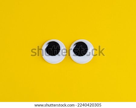 Cute googly eyes funny Isolated on bright yellow background copy space logo
