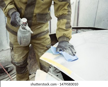 Cute Guy In Black Glasses With Black Gloves Displays The Shape Of The Hood For The Subsequent Painting Of The Car. Guy - A House Painter Working On A Car In The Garage