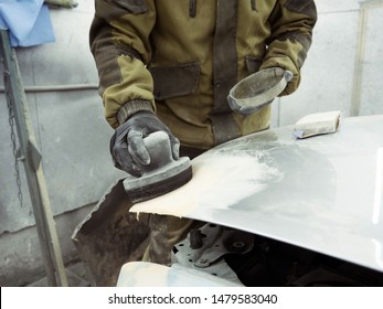 Cute Guy In Black Glasses With Black Gloves Displays The Shape Of The Hood For The Subsequent Painting Of The Car. Guy - A House Painter Working On A Car In The Garage