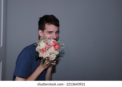 Cute Guy Holding A Bouquet Of Flowers In His Hands