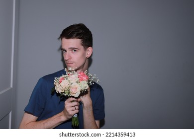 Cute Guy Holding A Bouquet Of Flowers In His Hands