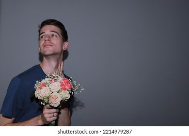 Cute Guy Holding A Bouquet Of Flowers In His Hands