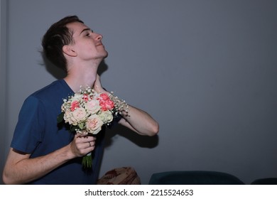 Cute Guy Holding A Bouquet Of Flowers In His Hands