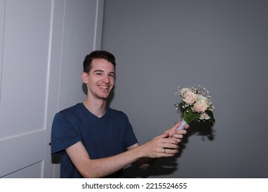 Cute Guy Holding A Bouquet Of Flowers In His Hands