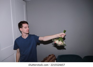 Cute Guy Holding A Bouquet Of Flowers In His Hands