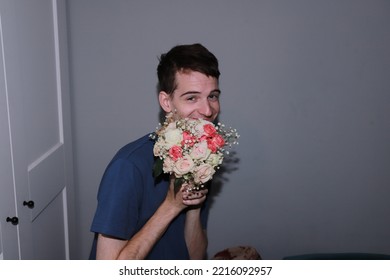 Cute Guy Holding A Bouquet Of Flowers In His Hands