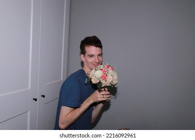 Cute Guy Holding A Bouquet Of Flowers In His Hands