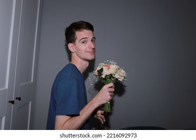 Cute Guy Holding A Bouquet Of Flowers In His Hands