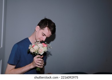 Cute Guy Holding A Bouquet Of Flowers In His Hands