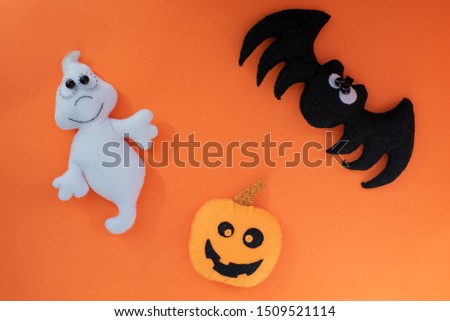cute halloween concept. hand made kids toy. pumpkin head, ghost, bat on orange background. top view