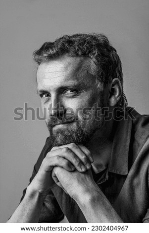 Cute and handsome caucasian man posing in photo studio with hands together. Black and white photo, with white background, making it versatile and timeless addition to any project. High quality photo