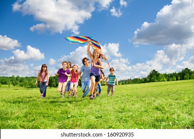 Cute Happy Active Kids Boys And Girls Run With Kite In The Park And Having Fun