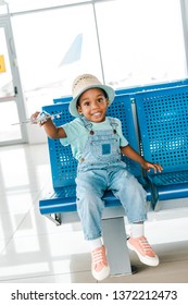 Cute Happy African American Boy Playing With Toy Plane In Airport