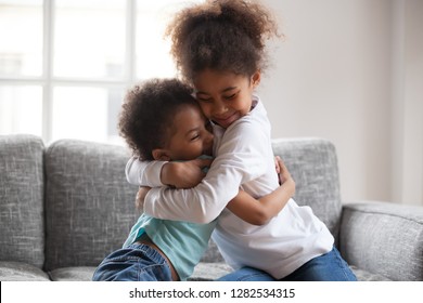 Cute happy african american siblings hugging cuddling feeling love and connection, smiling mixed race kid girl sister embracing little boy brother sitting on couch, 2 children good relationships - Shutterstock ID 1282534315