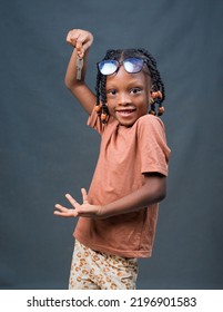 A Cute And Happy African Girl Child From Nigeria With Eye Glasses, Dancing And Holding House Keys In Her Hand