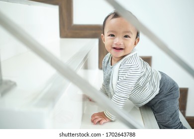 Cute Happy Asian 10 Months Old Toddler Baby Girl Child Climbing Up Stairs At Home Alone, Looking And Smiling At Camera, Movement, Balance & Coordination, Stair Climbing Developmental Milestone Concept