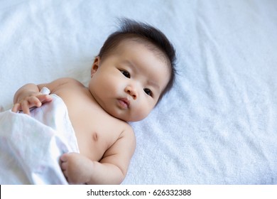 Cute happy Asian baby laying,  2 months after birth.