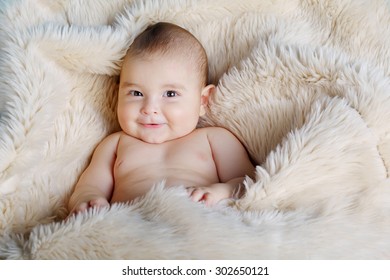 Cute Happy Baby Portrait Lying On Fur